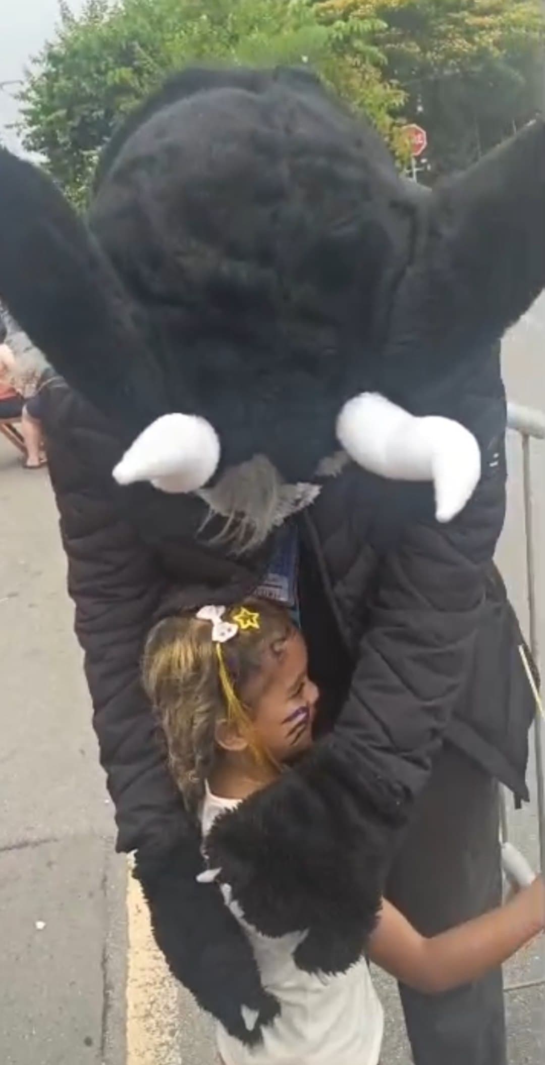 Criança abraçando um personagem de fursuit