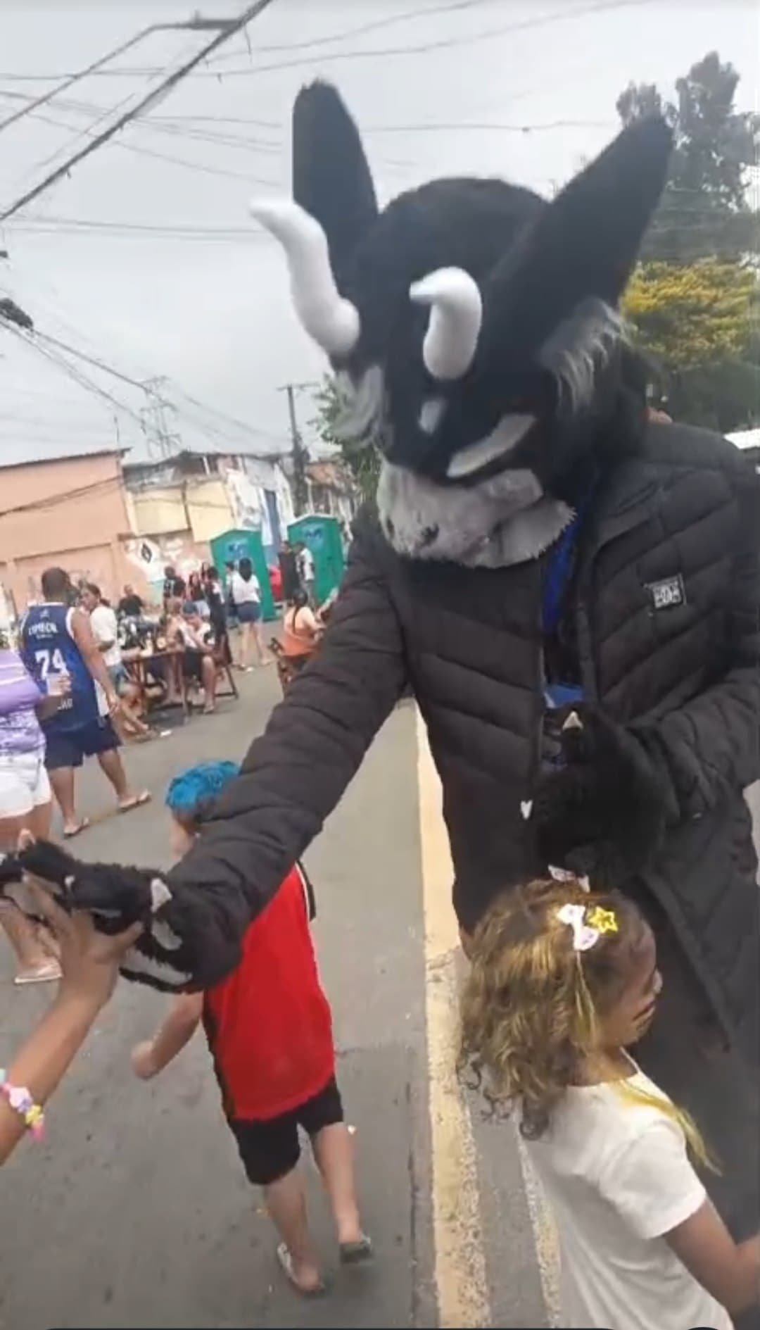 Personagem de fursuit cumprimentando crianças